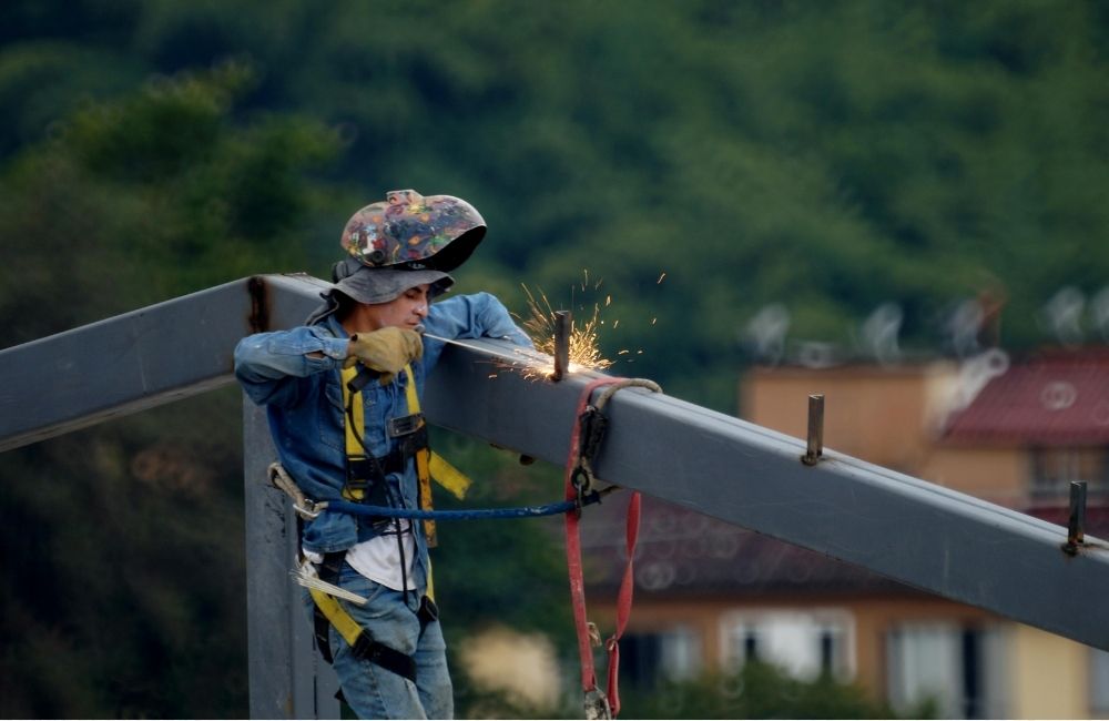 Construction worker installing steel frame for roof